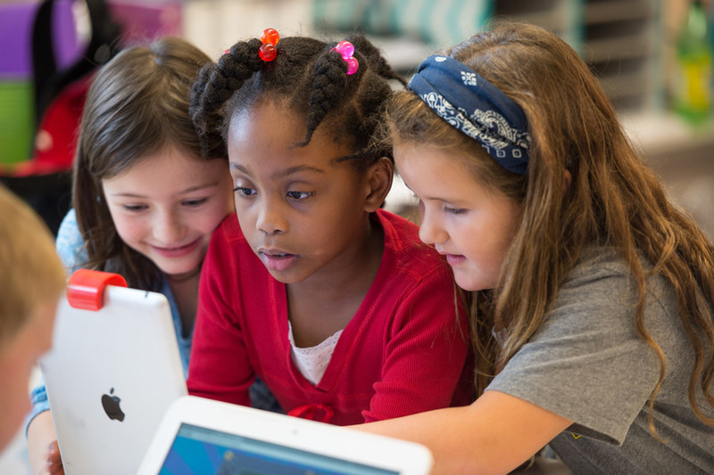 three students looking at laptop image